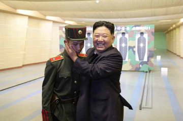 金正恩以手觸摸年輕學員的臉頰、頭部，似乎想展現關愛的模樣，但學員不僅全身僵硬，甚至連笑都相當尷尬，一動也不敢動。 圖：翻攝自Twitter
