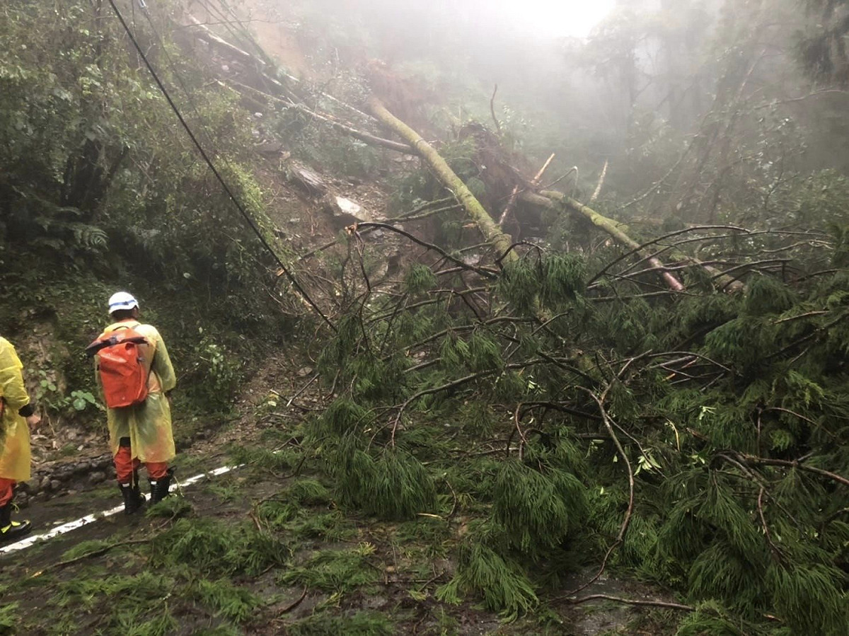 8名宜蘭縣消防局人員揹著物資要送進明池山莊，但台七線道路多處坍方，寸步難行。 圖：翻攝自林姿妙臉書