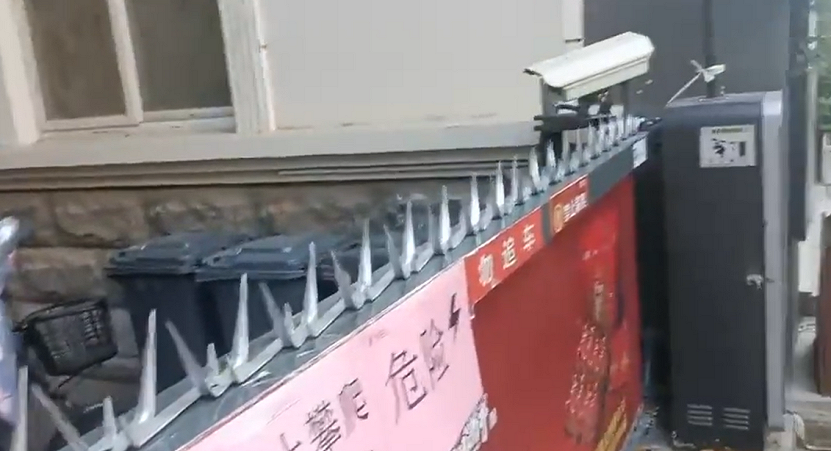社區為了怕民眾外出，用鐵製成的尖刺，並將其栓在社區門上。 圖：翻攝自CCAVNewsShorts推特