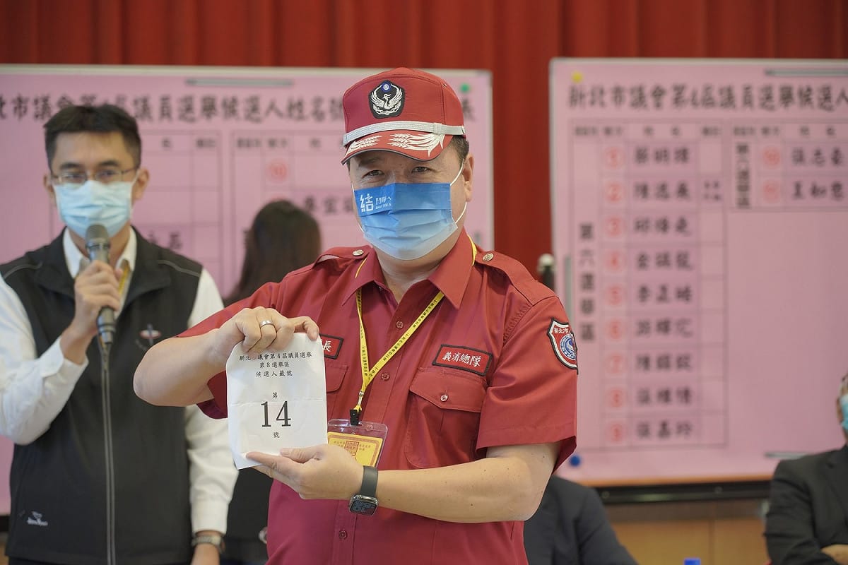 穿著義消紅色制服的新北市議員林金結抽到14號，現場一陣大叫「跟上次完全一樣」。 圖：林金結辦公室提供