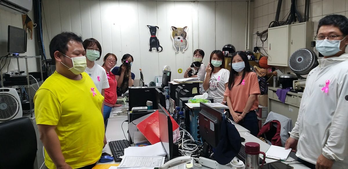 板橋動物之家人員別上粉紅絲帶提倡乳癌防治的重要。 圖：新北市動保處提供