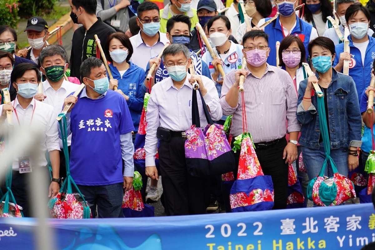 台北市長柯文哲率領民眾一起挑起擔頭，為「2022台北客家義民嘉年華」挑擔奉飯揭開序幕，可看見無黨籍台北市長候選人黃珊珊、民進黨候選人陳時中及國民黨候選人蔣萬安也出席。 圖：台北市政府 / 提供