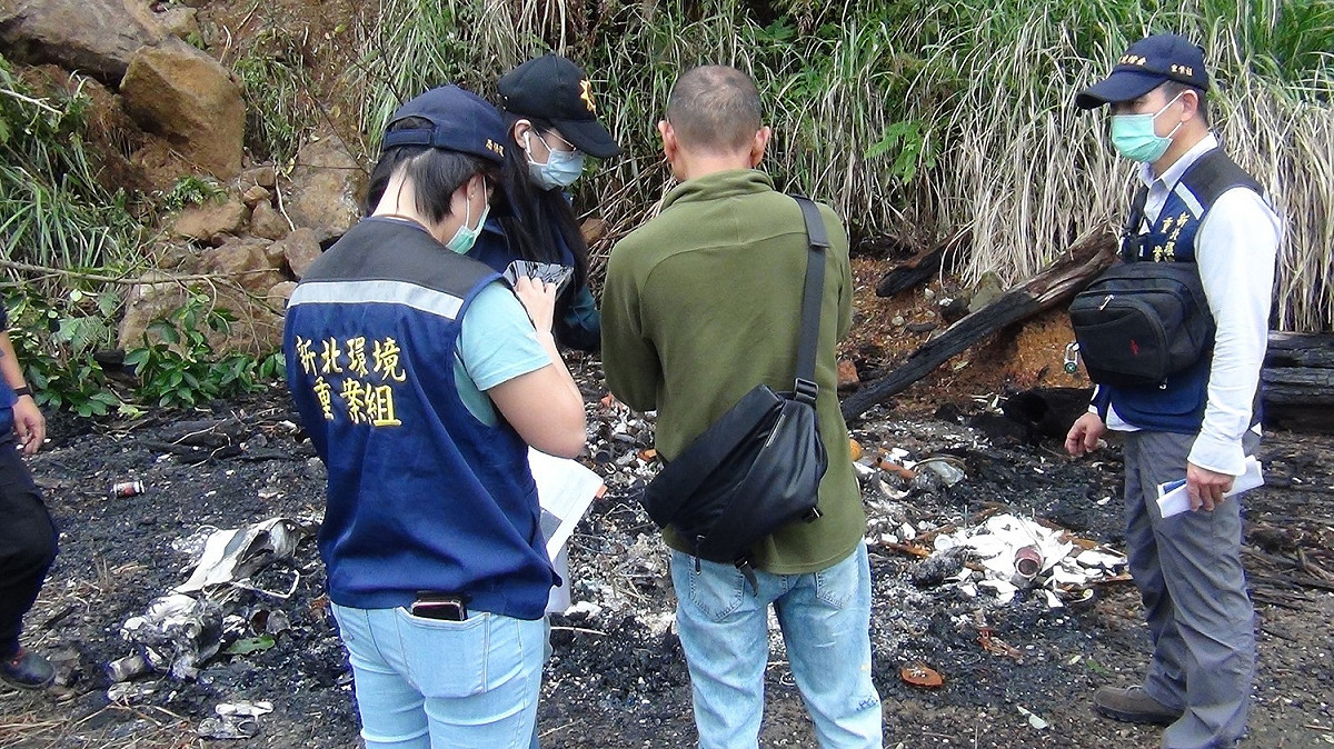 新北環境稽查重案組21日會同保七總隊刑事警察大隊，由士林地方檢察署檢察官指揮搜索破獲不法分子於三芝區木屐寮山上非法焚燒及掩埋廢棄物。 圖：新北市環保局提供