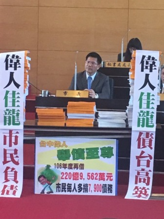 台中市議會國民黨議員21日在市長林佳龍堆起預算書，並掛上對聯 圖：台中市議會國民黨團提供
