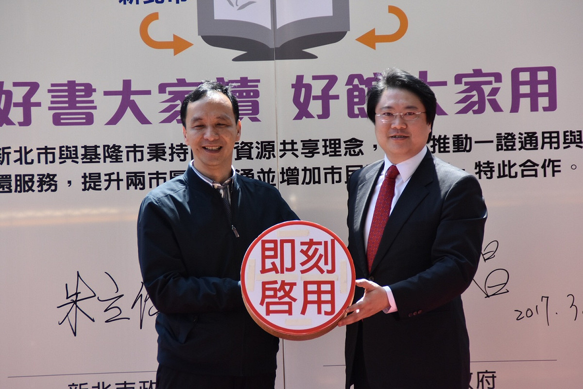 基隆市長林右昌（右）與新北市長朱立倫（左）24日在新北市立圖書館總館，簽署閱讀合作備忘錄，啟用「一證通用」及「聯合通還」服務。 圖：基隆市政府提供。