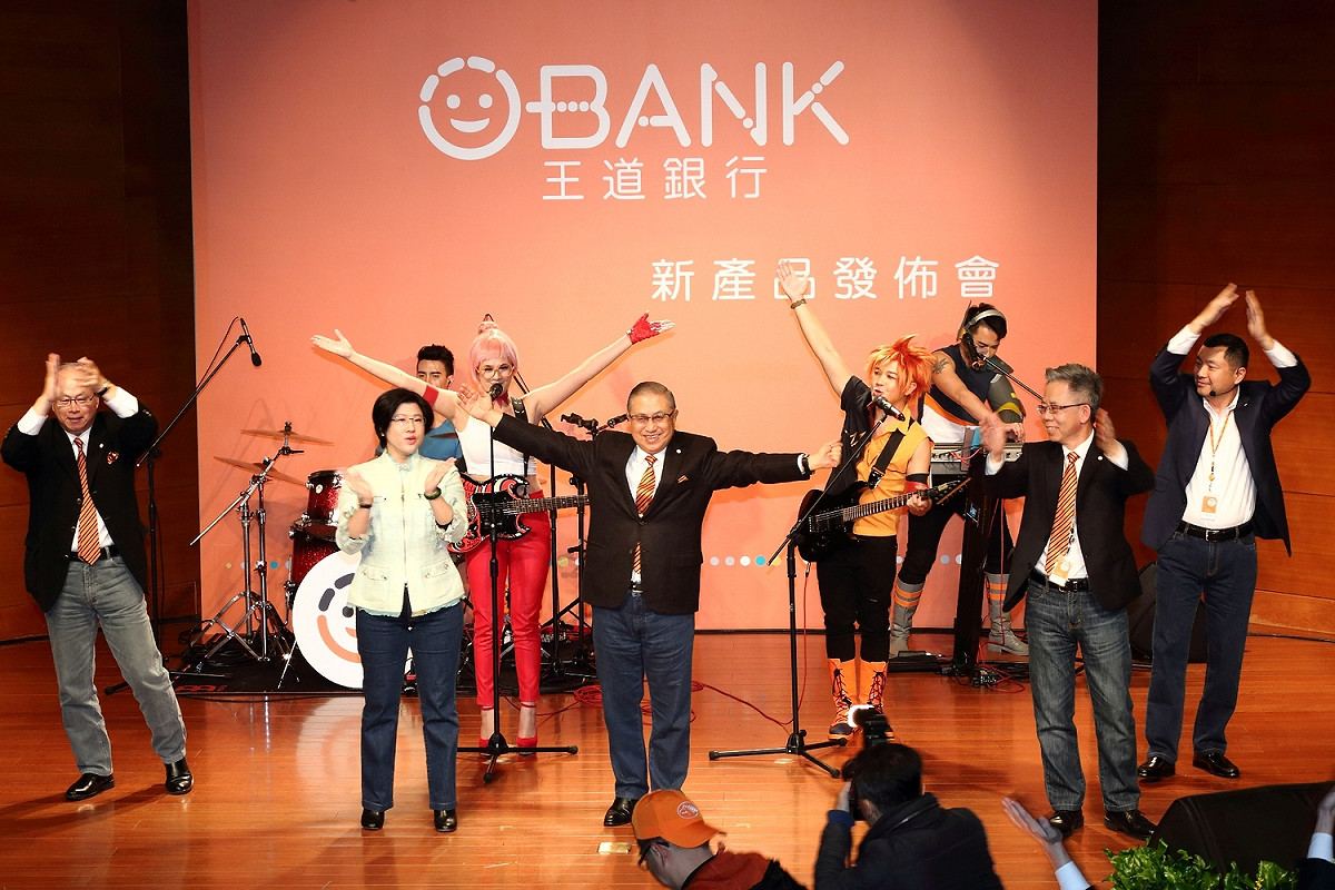 王道商業銀行以年輕人為主要訴求對象，所以品牌也全面年經化，董事長駱錦明跟所有員工一起穿上牛仔褲，跟代言樂團一起上台歡樂。 圖：王道銀行提供