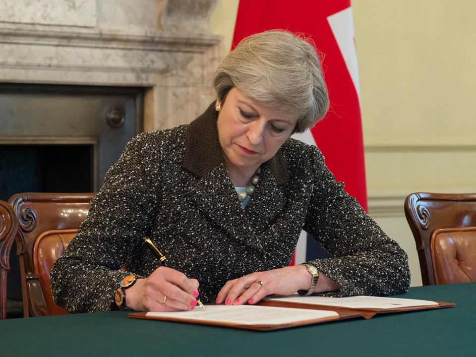 英國首相梅伊正式簽署文件，將由脫歐大臣交給歐盟主席，正式啟動脫歐時程。 圖：翻攝唐寧街10號臉書
