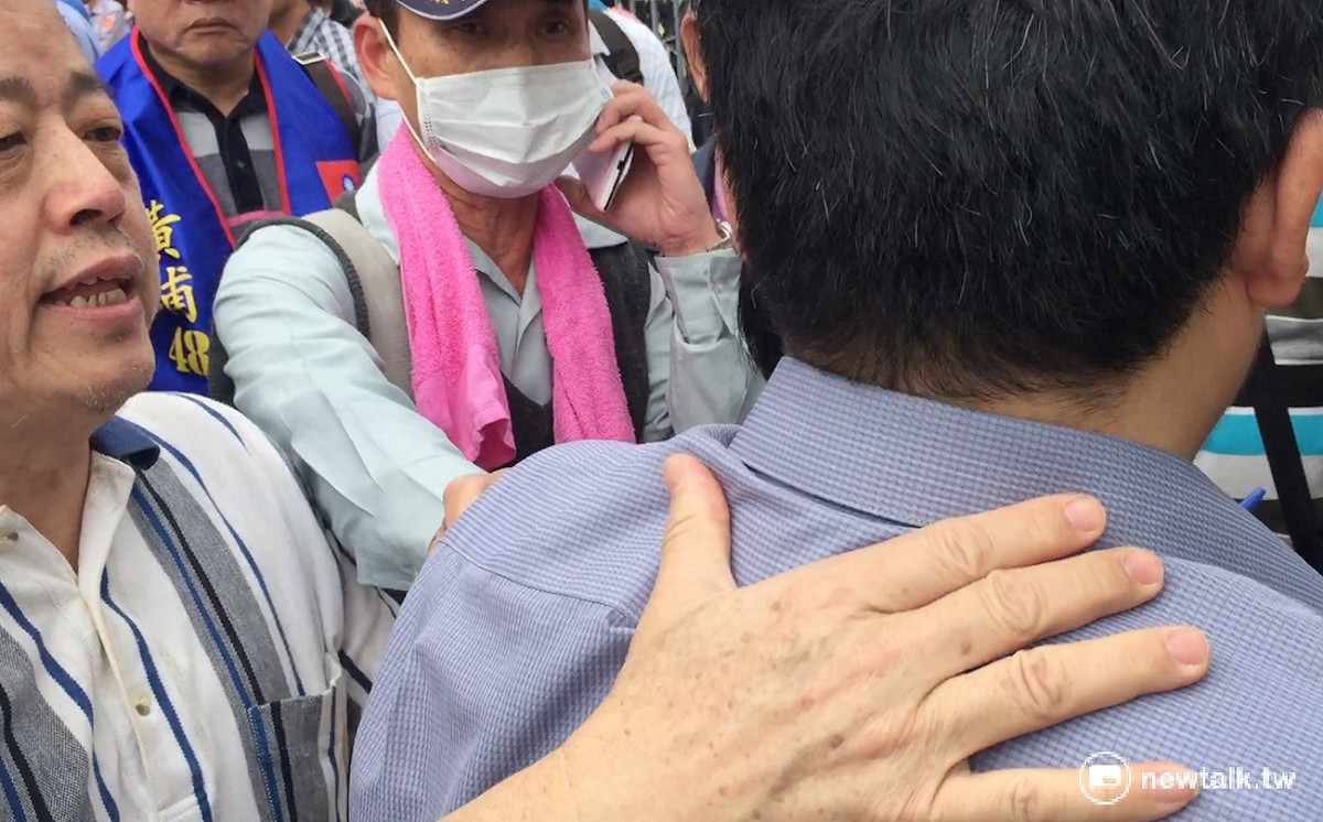 前立委錢達不滿在場記者不出示記者證，準備動手將記者推出採訪現場。 圖：翻攝自現場影片