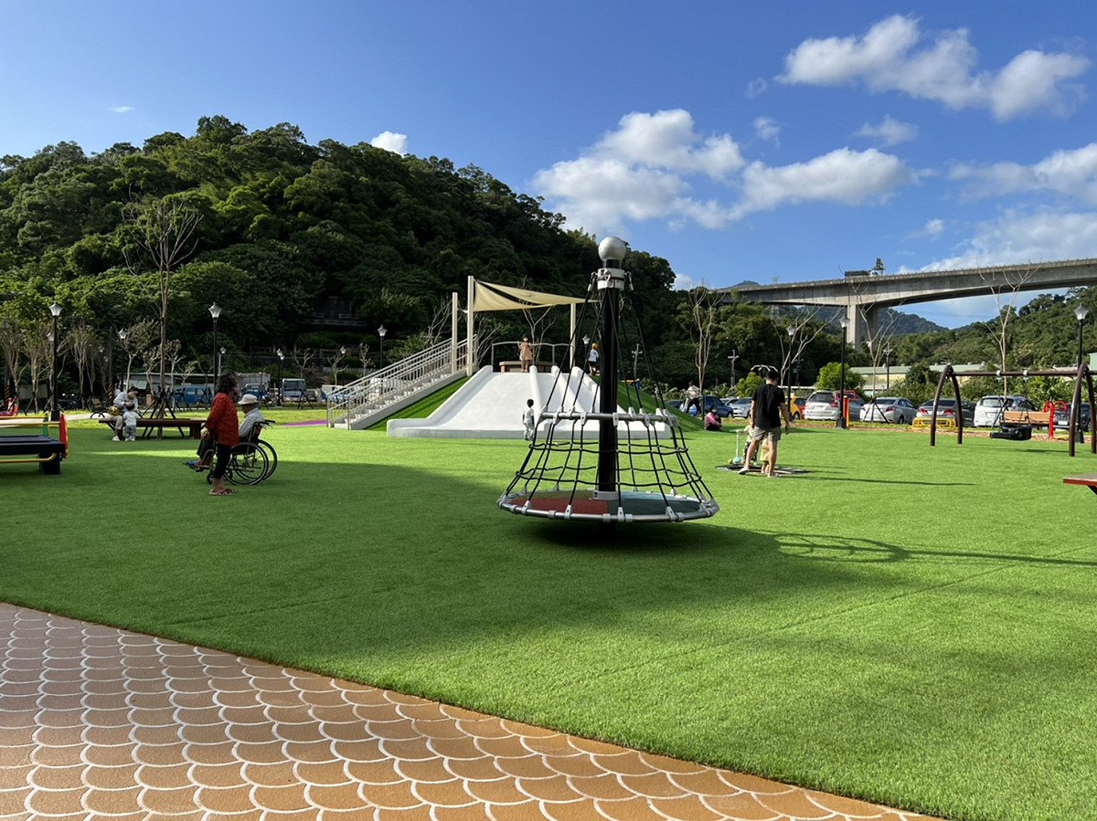位於觀音坑溪天乙路附近約有2600平方公尺公有土地，遭民眾長期占作停車場，在協調排除占用後，以「共融式遊戲場」方向進行規劃天乙公園，包括爬繩、鳥巢鞦韆、親子鞦韆、旋轉網塔、跳床、翹翹板等設施，另有土丘溜滑梯，在疫情逐漸緩和之際，可提供民眾戶外休閒新去處。 圖：新北市工務局提供