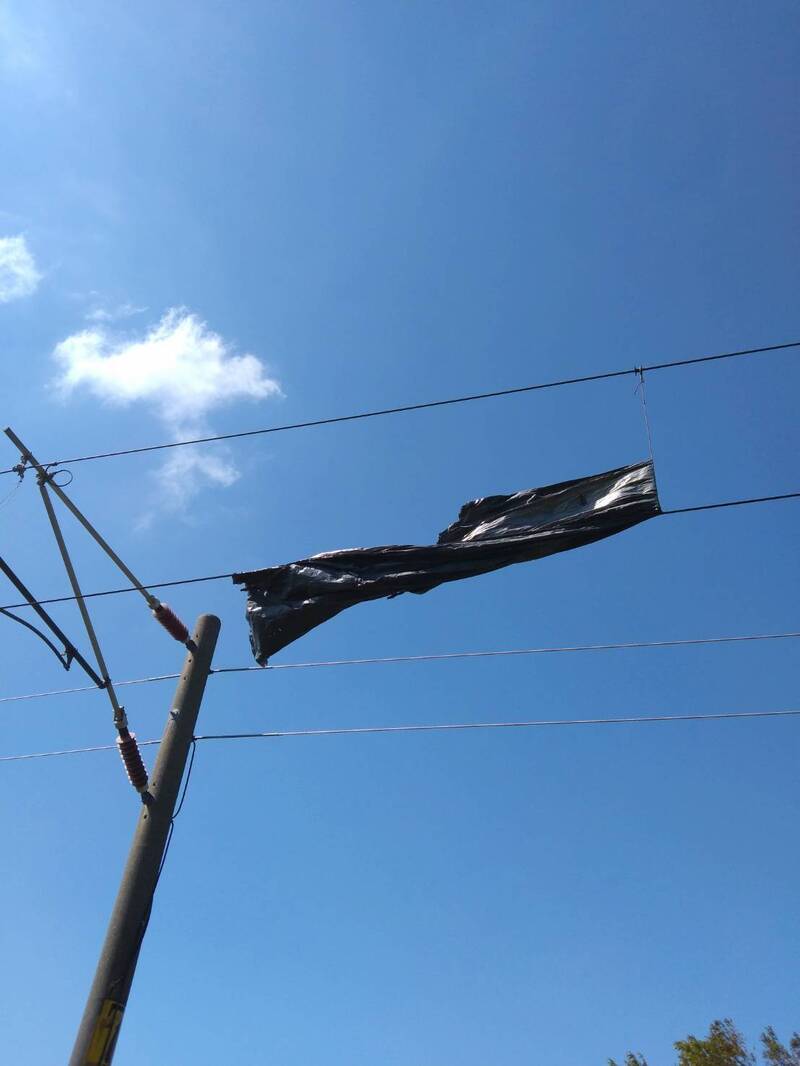 台鐵海線路段白沙屯－新埔間，就有布條侵入纏繞到電車線，導致行車一度中斷，目前已恢復行駛。 圖：台鐵局／提供