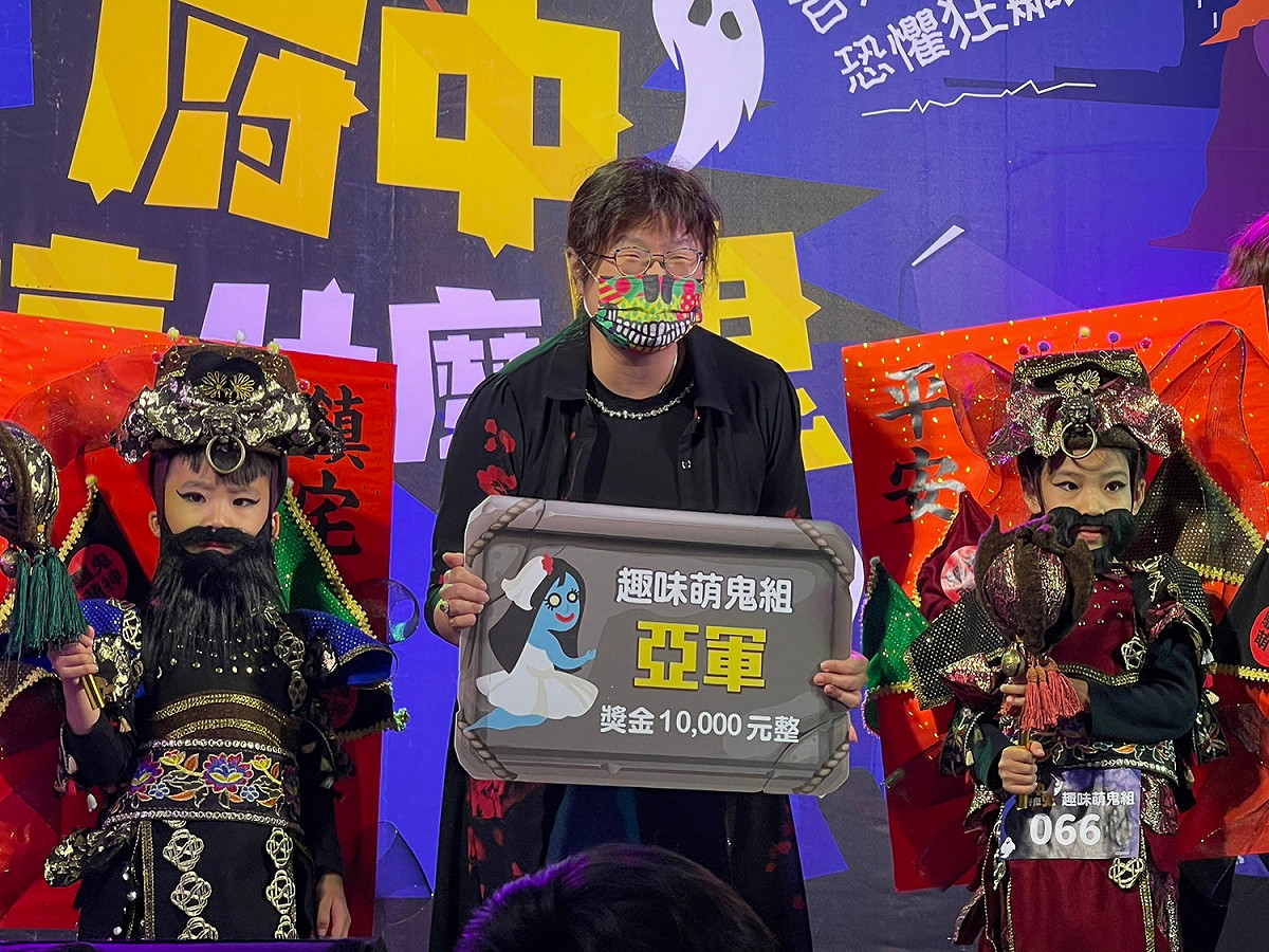 趣味組亞軍為「鬼才會怕怕-威萌門神」，超萌打扮吸引許多民眾合影，由經發局長何怡明（中）頒獎。 圖：新北市經發局提供