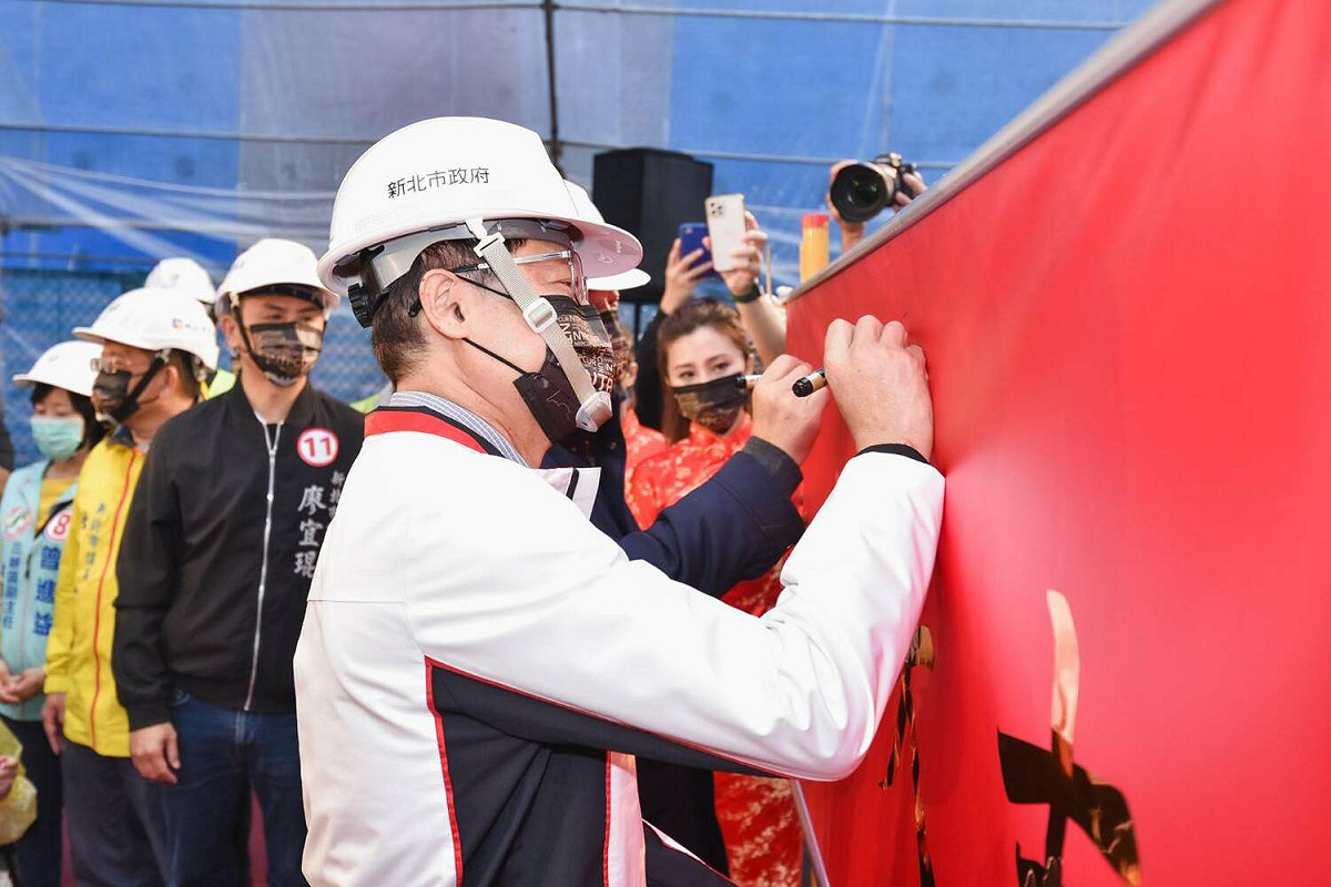 陳純敬於上梁典禮祈福布條上簽名。 圖：新北市城鄉局提供