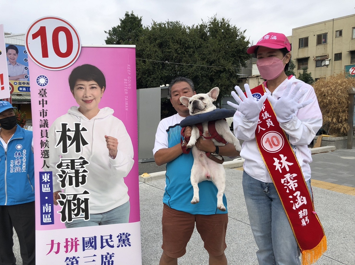 支持者包著毛小孩陪林霈涵站路口拉票。 林霈涵競選總部/提供