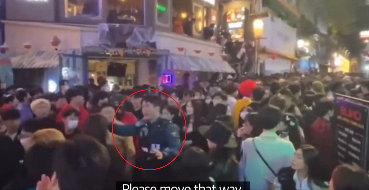 一名韓國警察在梨泰院人群中喊話，叫人潮不要再往前擠，但似乎沒人聽勸。 圖：翻攝自推特