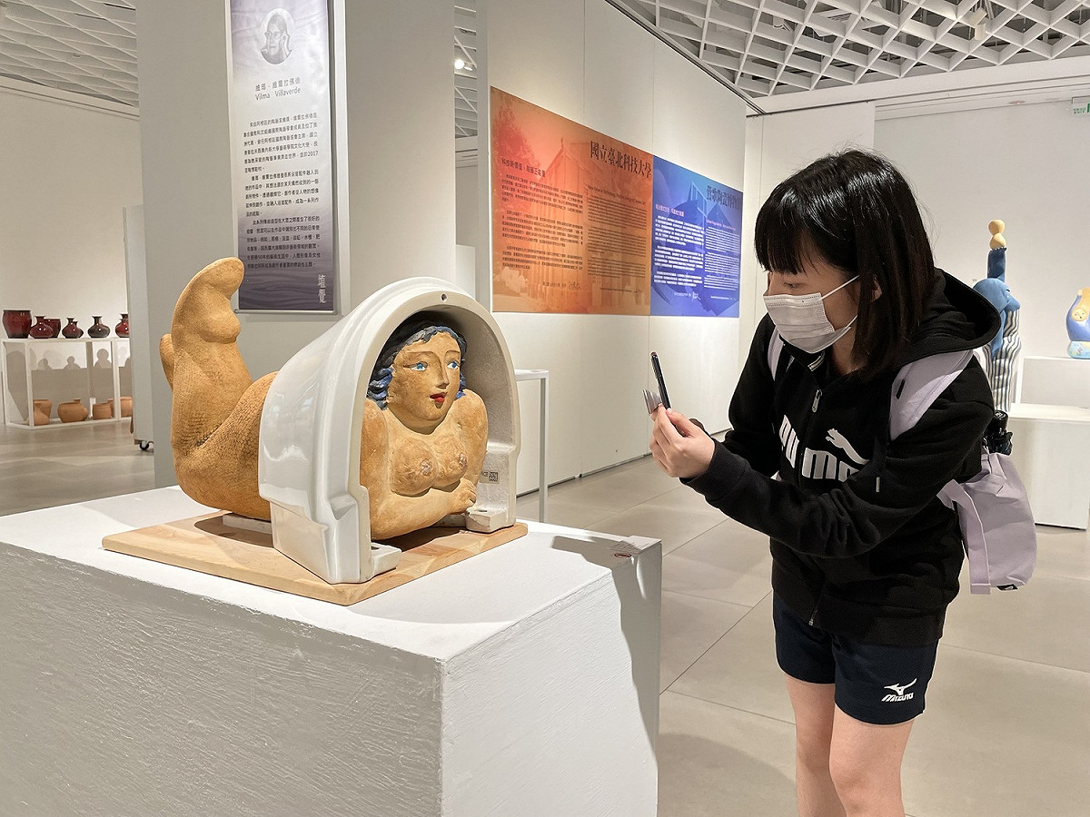 阿根廷Vilma Villaverde《窗台前》，以洗手台造型當作窗台，人物愜意地趴在窗台上等候，俏皮可愛的模樣逗樂觀眾的視覺。 圖：鶯歌陶瓷博物館提供