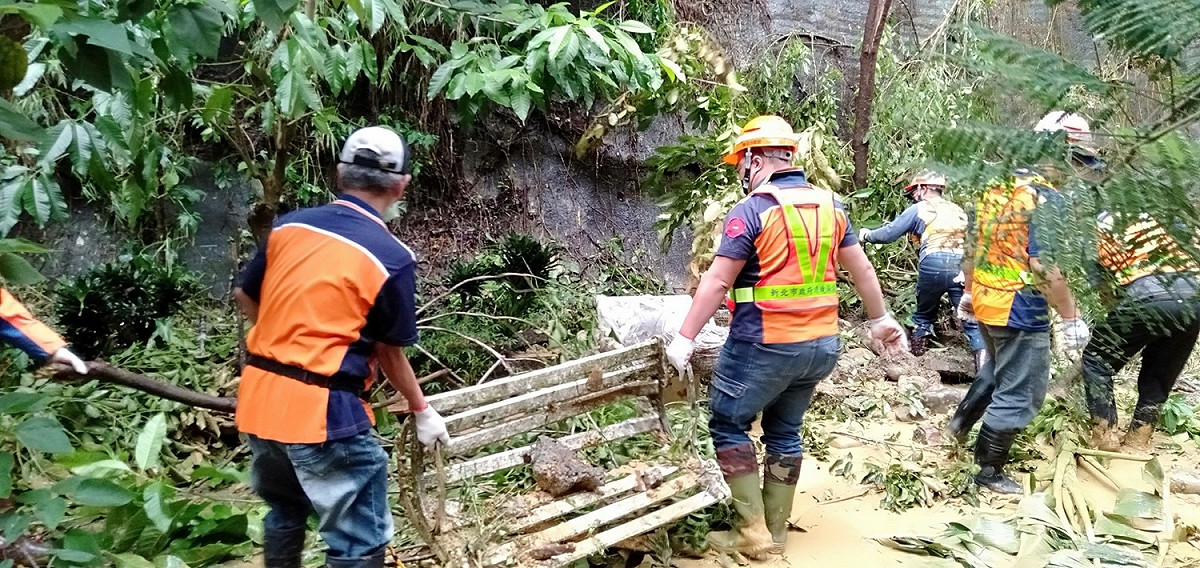 汐止伯爵山莊受暴雨影響，清潔隊員前往復原，用人力挖除落土。 圖：新北市環保局提供