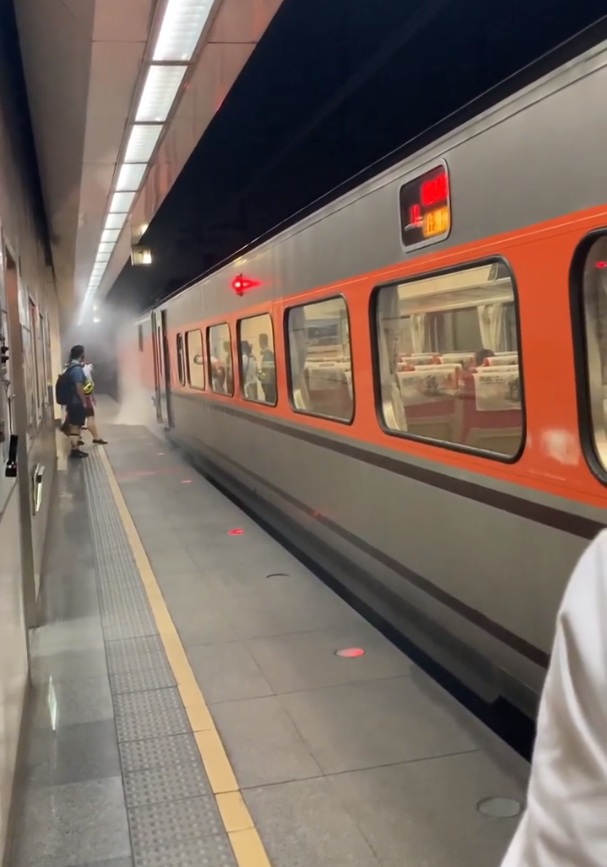 台鐵143次自強號列車在松山站時，發生機車「閘瓦」(煞車皮)咬死車下冒煙著火意外。 圖：合鐵事故通報平台影片截圖