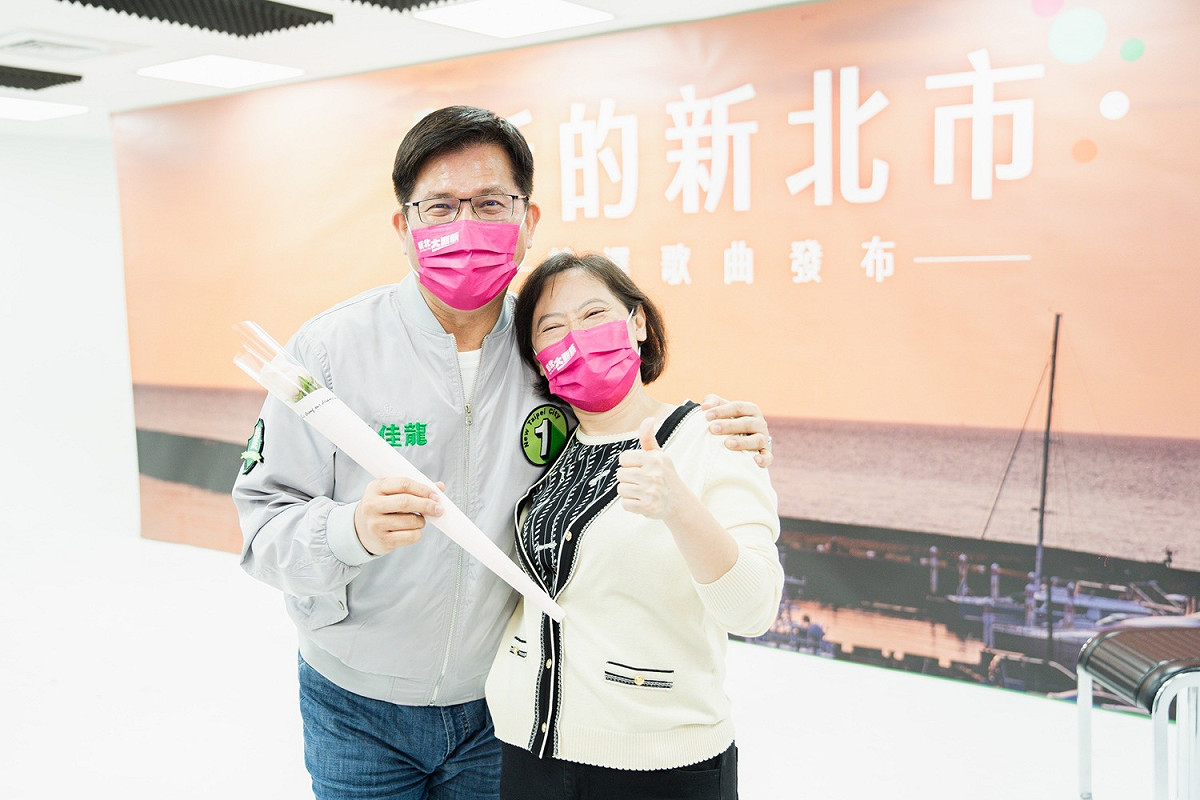 林佳龍疫後歸來，手持象徵純真、彼此信任與託付的粉紅玫瑰花進行合唱。 圖：林競辦提供