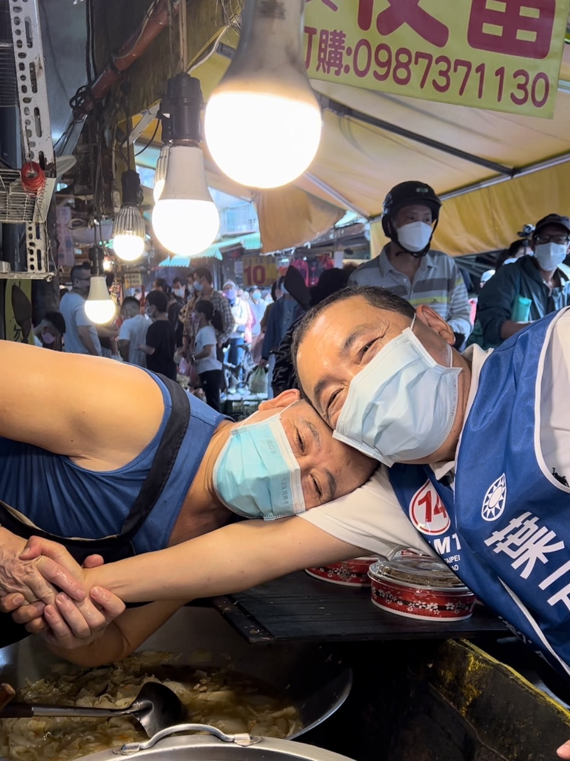 鐵粉攤商見到侯友宜，立刻用頭碰頭方式祝高票當選。 圖：侯友宜選辦/提供