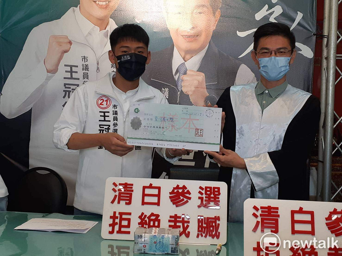 王冠鈞（左）將一百萬元懸賞獎金交給律師。 圖：蔡坤龍/攝