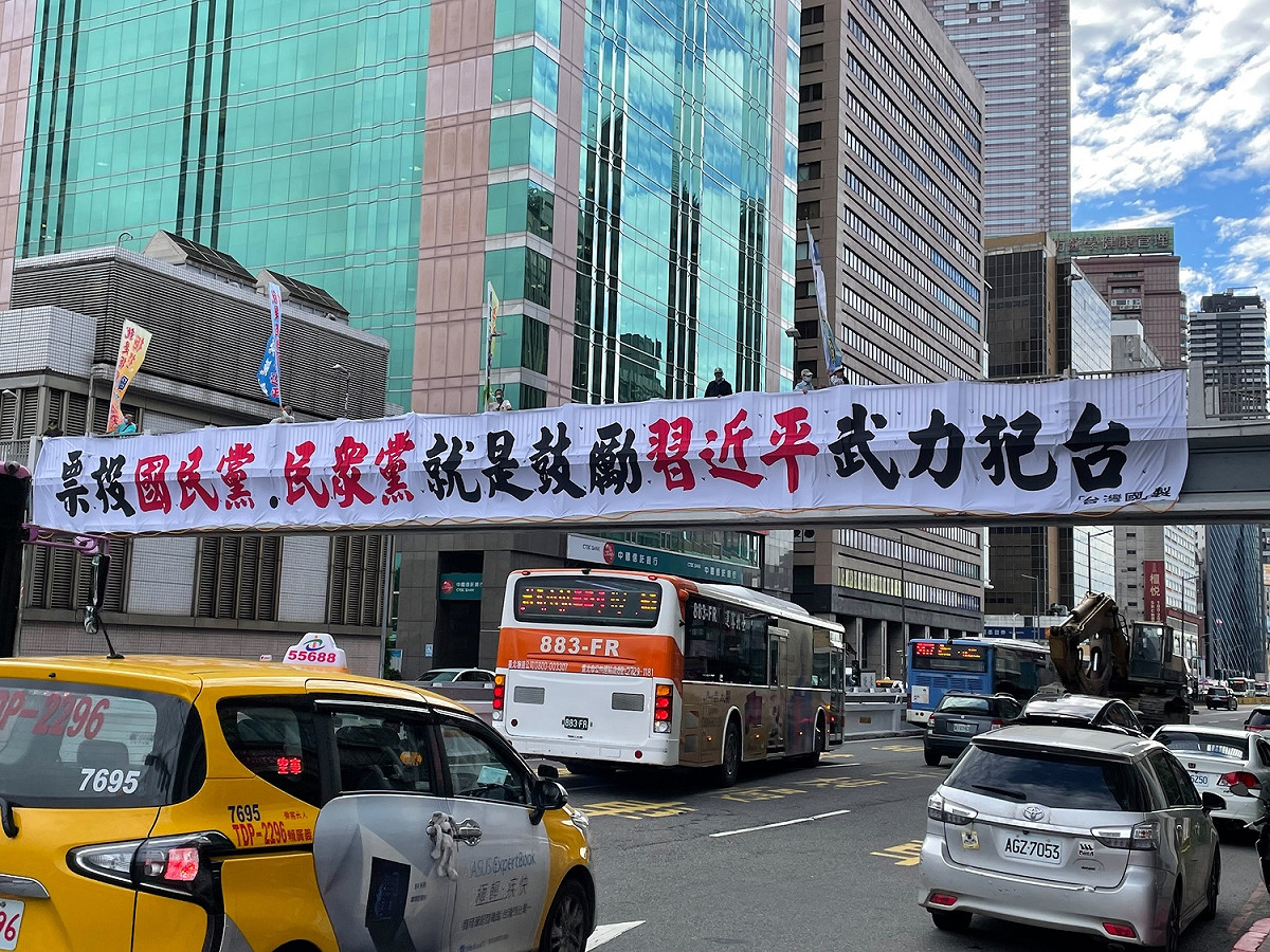 獨派台灣國在台北市忠孝西路陸橋高掛「票投國民黨、民眾黨就是鼓勵習近平武力犯台」大型布條。 圖：台灣國 / 提供