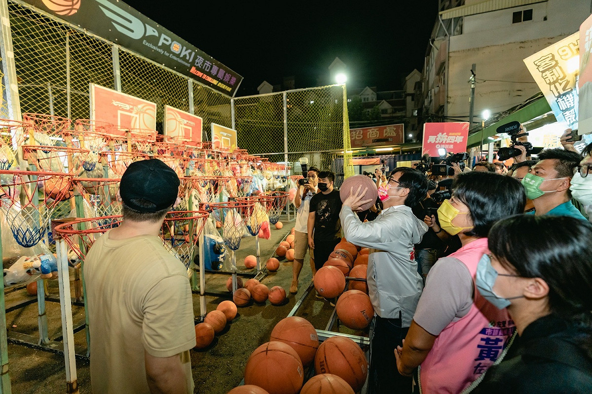 陳其邁在夜市玩投籃遊戲。 圖：陳其邁競總提供