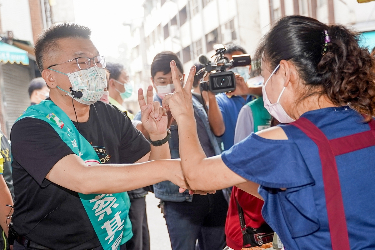 蔡其昌到市場拜票，攤商熱情地比出「2」號表示支持。 蔡其昌競選總部/提供