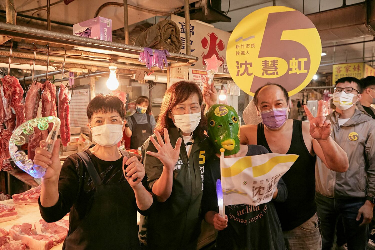 民進黨新竹市長候選人沈慧虹今（19）日至新竹果菜市場拜票，還有人自製青蛙頭套表示「5力5哇（蛙）」，許多人也送上蔥、蒜，表達支持祝福她。 圖：沈慧虹競辦提供