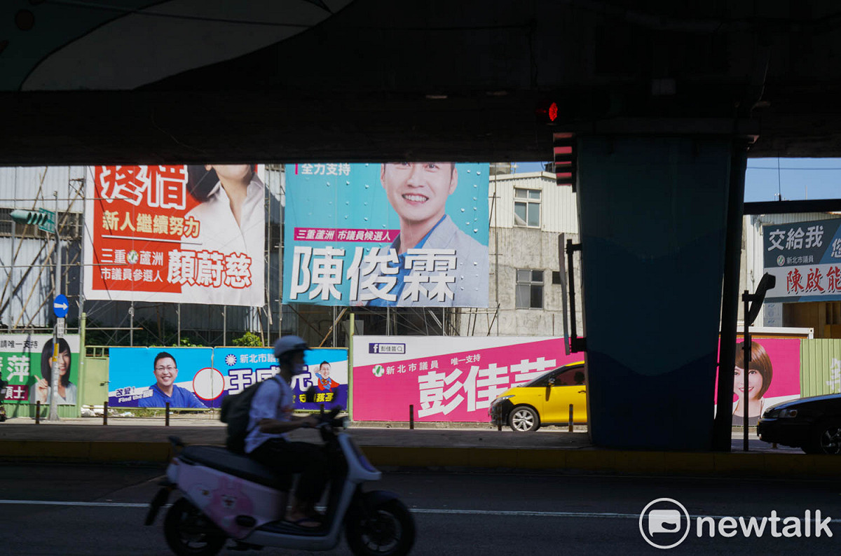 新北市三重區高架橋下貼滿了候選人的競選看板，五彩的顏色讓人不注意也難。 圖：張良一/攝