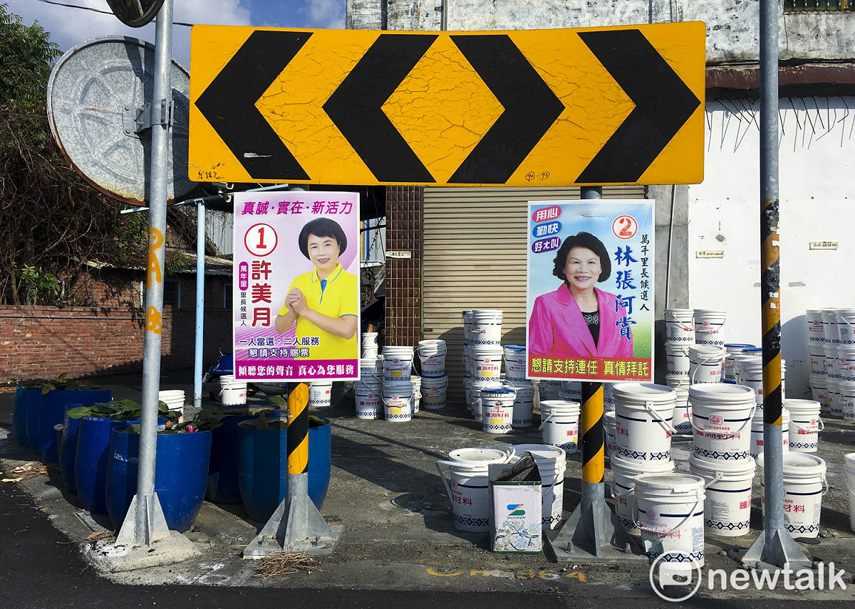 兩位里長候選人將她們的競選看板直接掛在交通標誌上面。 圖：張良一/攝