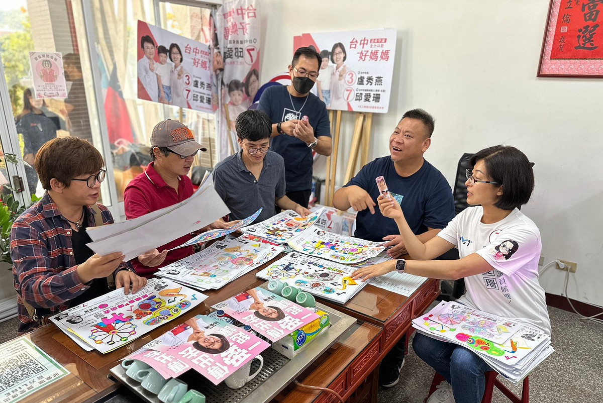 洪易等人欣賞孩子們的作品。  邱愛珊競選總部/提供