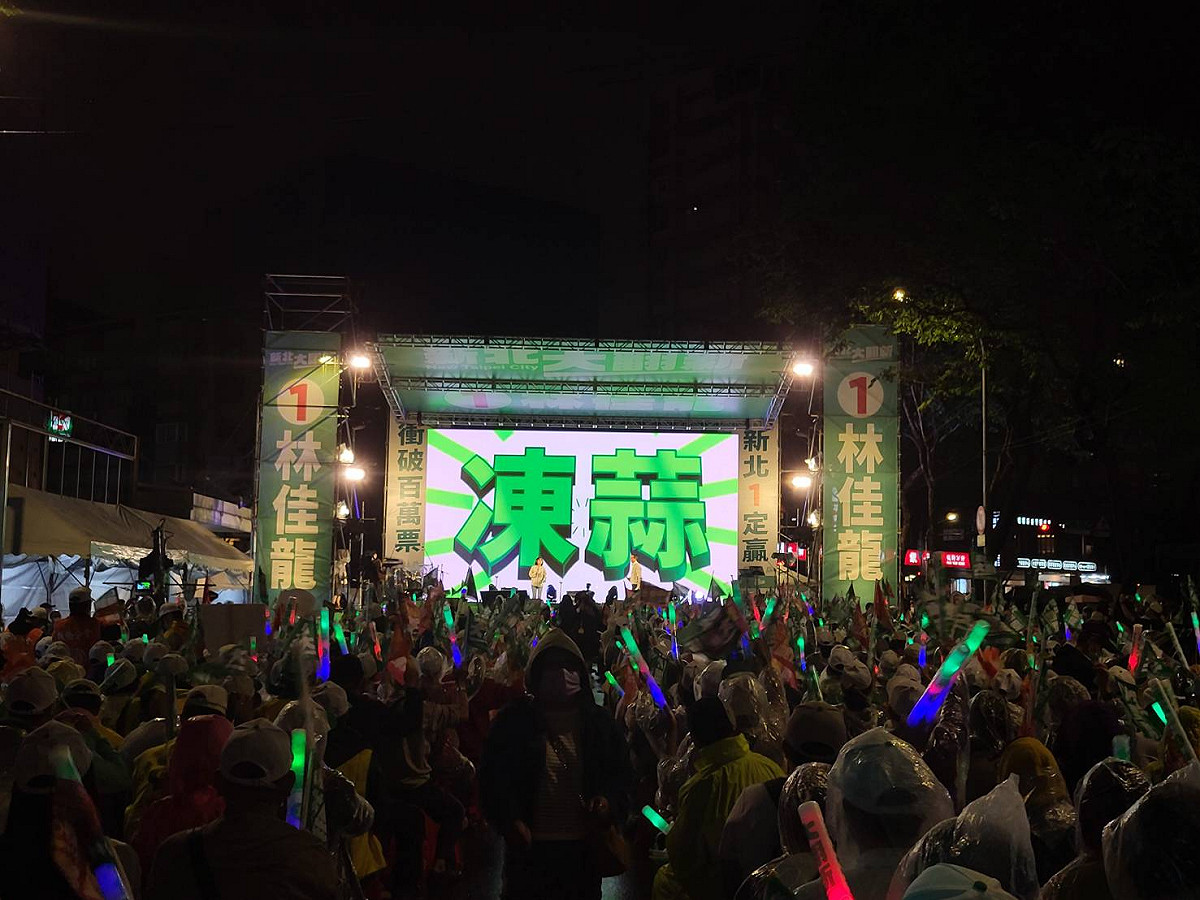 林佳龍還未現身，民眾仍興奮高舉旗幟。 圖:陳佩君/攝