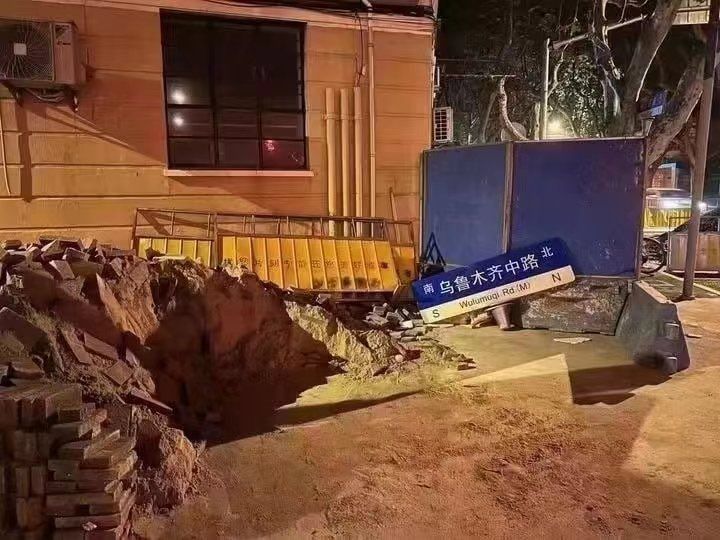 中國當局把抗議地點「烏魯木齊中路」路牌拆下棄置路邊，想移除現場抗議活動的「象徵」。 圖：翻攝推特