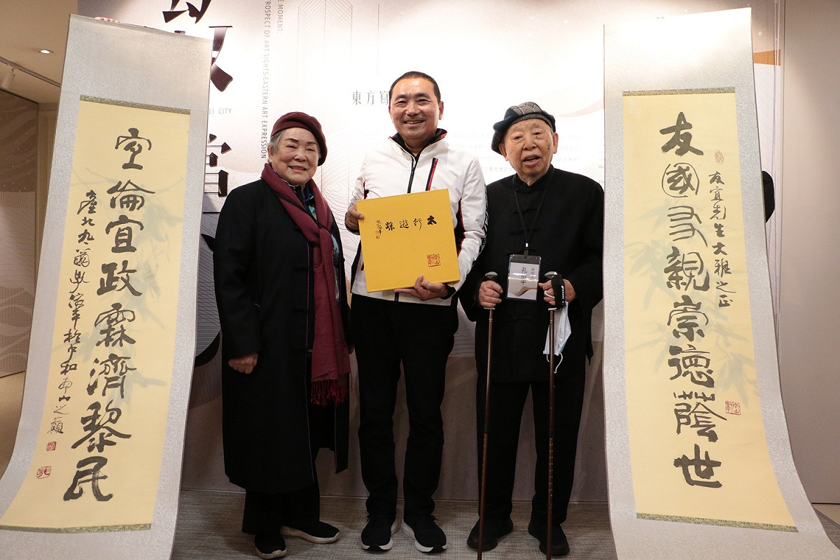 「致當下」藝術家孔依平（右）以侯友宜（中）名字為題寫對聯祝福侯友宜。 圖：新北市文化局提供