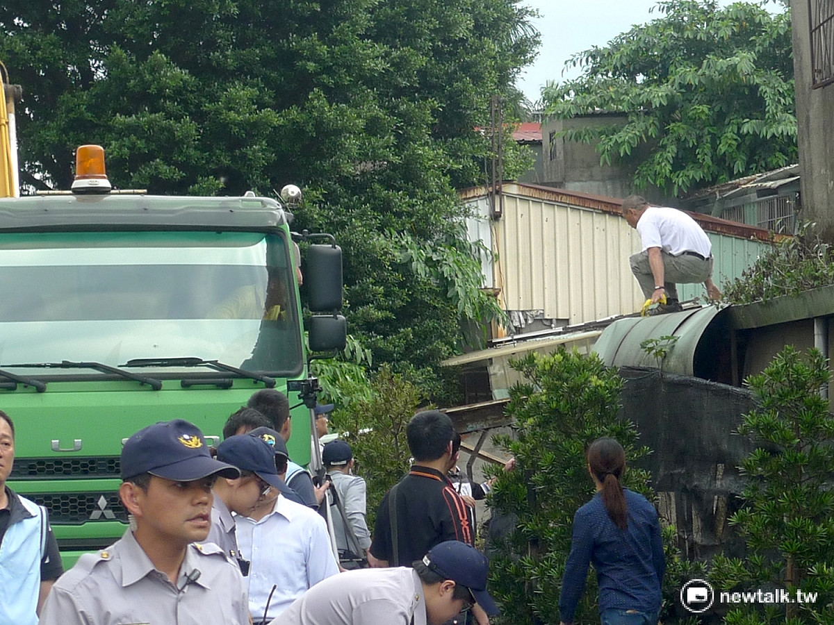 榮民攀爬屋簷企圖阻擋怪手。 圖：汪少凡／攝