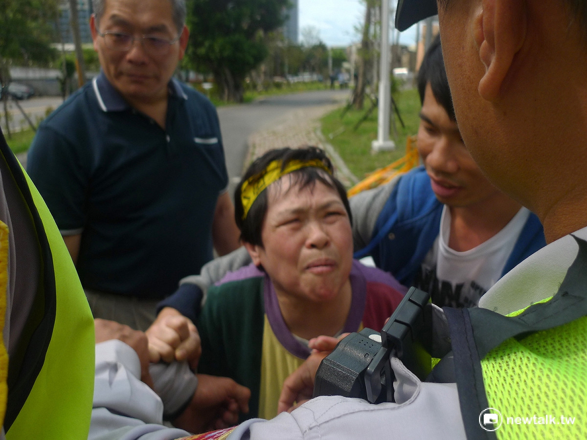 榮民拉住警方不願放手，哀求不要拆她房屋。 圖：汪少凡／攝