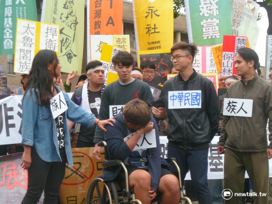 原民青年還在政院前演出《砍你雙腳、再賣你輪椅》的行動劇。 圖：謝莉慧/攝