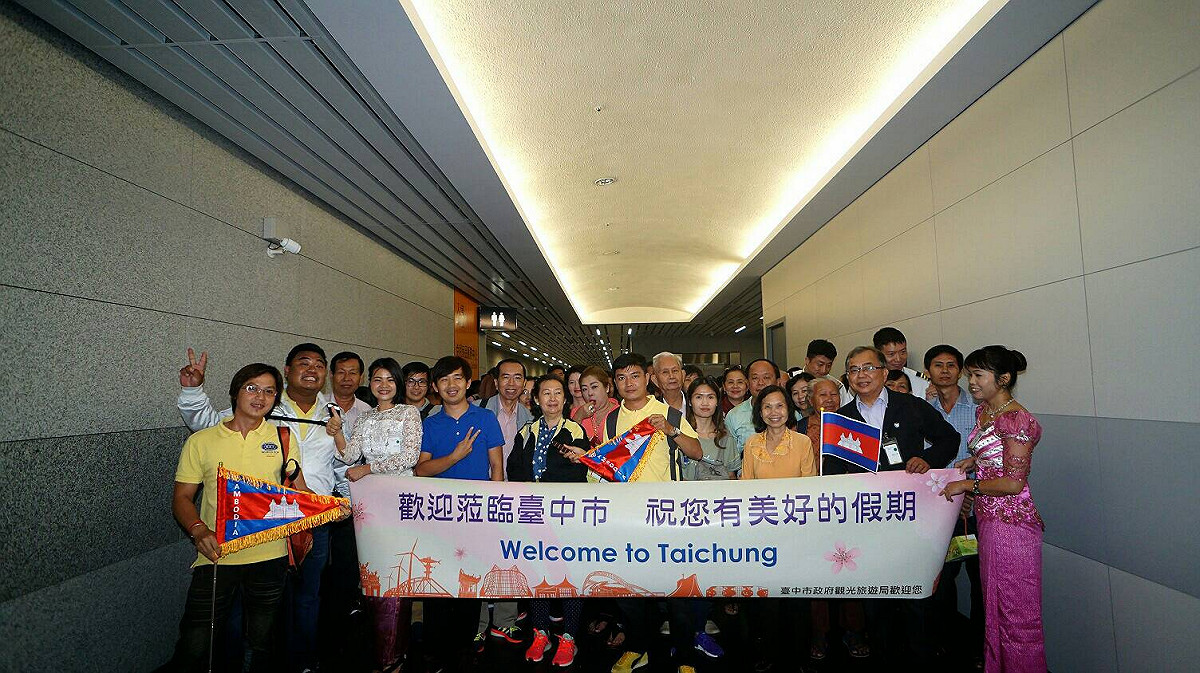 為迎接首批來台柬埔寨遊客，政府特地邀請來自柬埔寨的新住民們持旗、拉布條歡迎。 圖：由台中市政府提供
