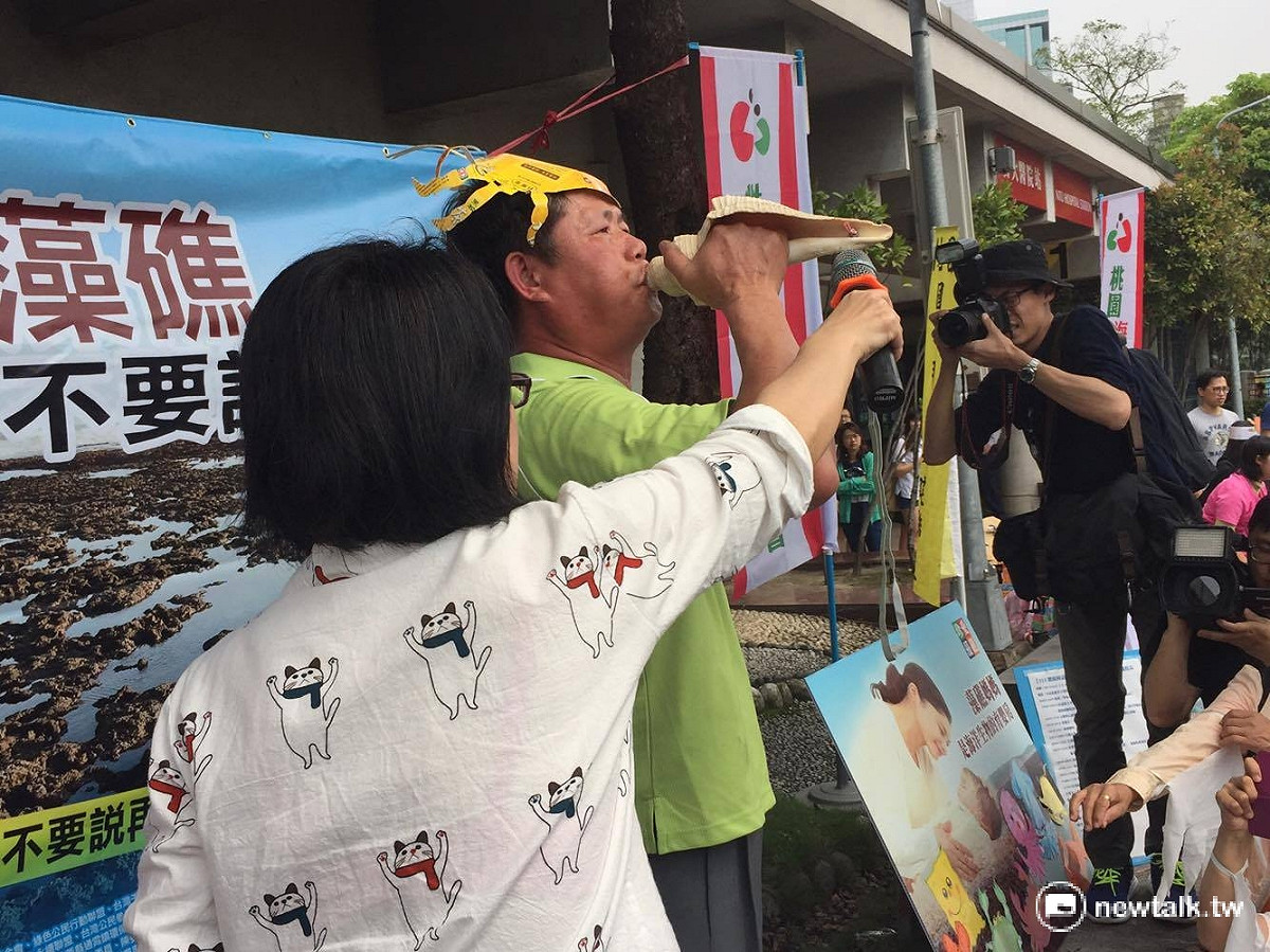桃園海岸生態保護理事長葉斯桂現場吹了3聲海螺，盼自然藻礁別成為財團下的犧牲品。 圖：鄭佑漢/攝