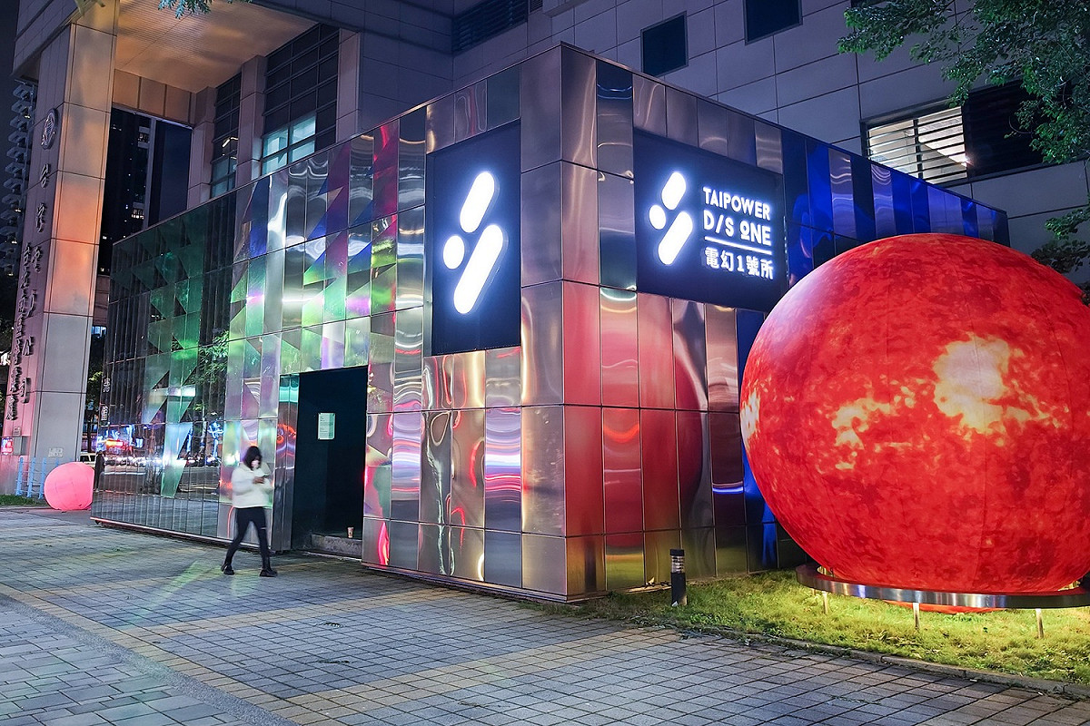 電幻1號將展館入口處以215片不鏽鋼板打造成的裝置藝術《城市光井》換上冬裝，搖身成可七彩變化的儲能貨櫃意象，搭配象徵太陽的互動變色光球。 圖：台灣電力公司／提供