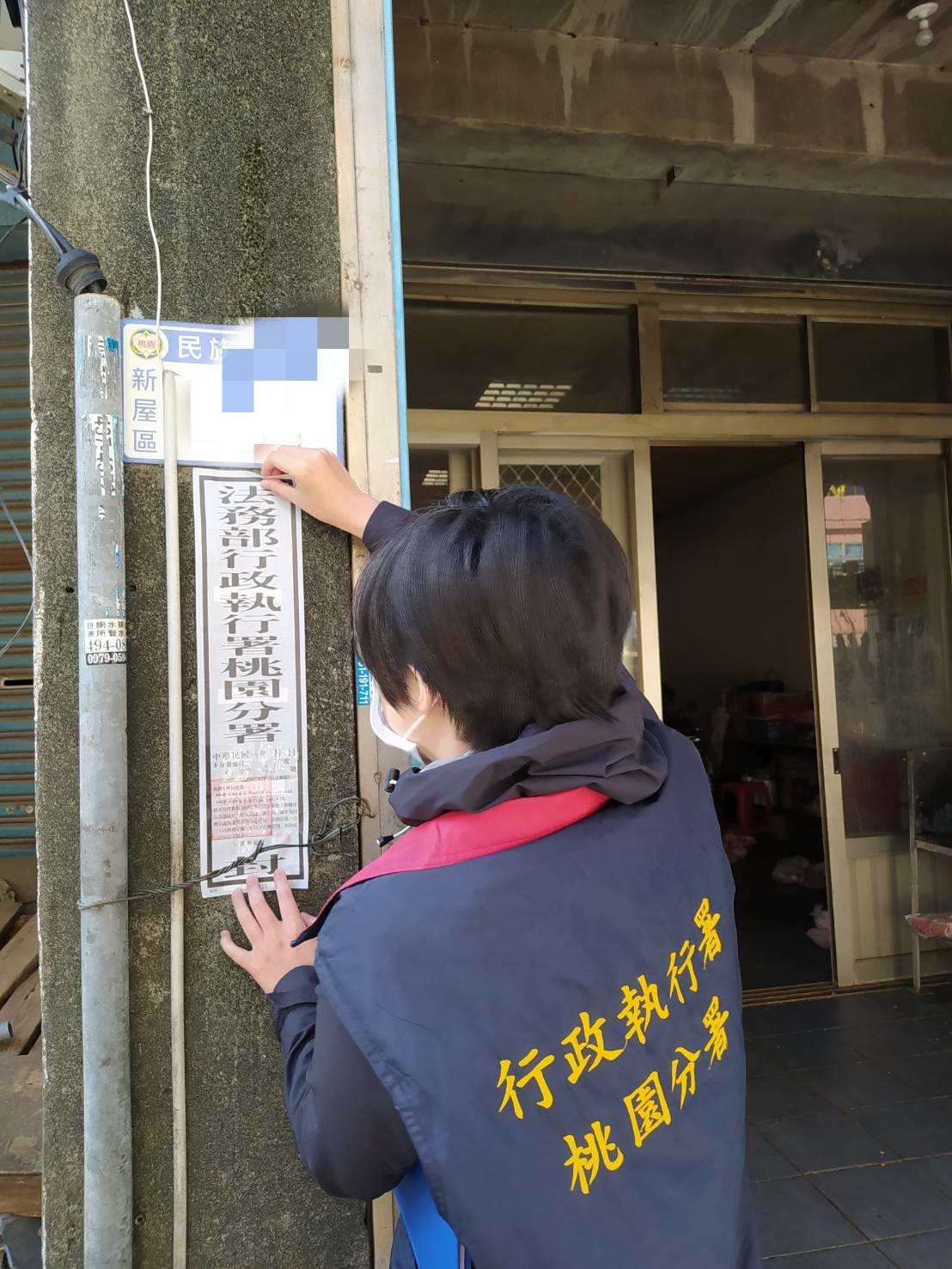 桃園分署執行人員現場張貼封條，並留下通知書請盧男弟弟幫忙轉交，務必請盧男聯繫書記官處理繳款事宜。 圖：行政執行署桃園分署／提供