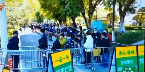 中國放寬封控管制後，不但讓確診和死亡人數飆升，更讓國內經濟加速惡化。圖為廣東民眾大排長龍替死亡親屬領證明。 圖 : 翻攝自中國廣東電視台畫面