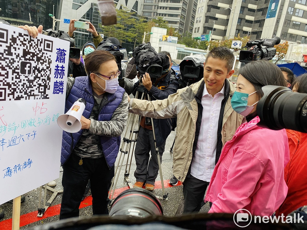 民進黨立委補選候選人吳怡農今早站路口遇到無黨籍對手蕭赫麟（紫色背心）突襲下戰帖要求辯論。 圖：周煊惠 / 攝