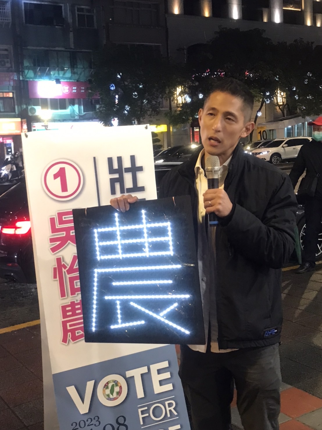 北市立委補選民進黨候選人吳怡農29日於民權西路捷運站附近進行街講，支持者送上自製的LED，大大寫上一個農字。 圖：朱蒲青／攝