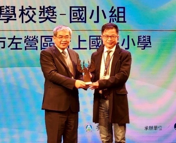 王彥嵓(右)從曾任高市教育局長的教育部政次蔡清華手中接過獎座。 圖：高雄市新上國小/提供