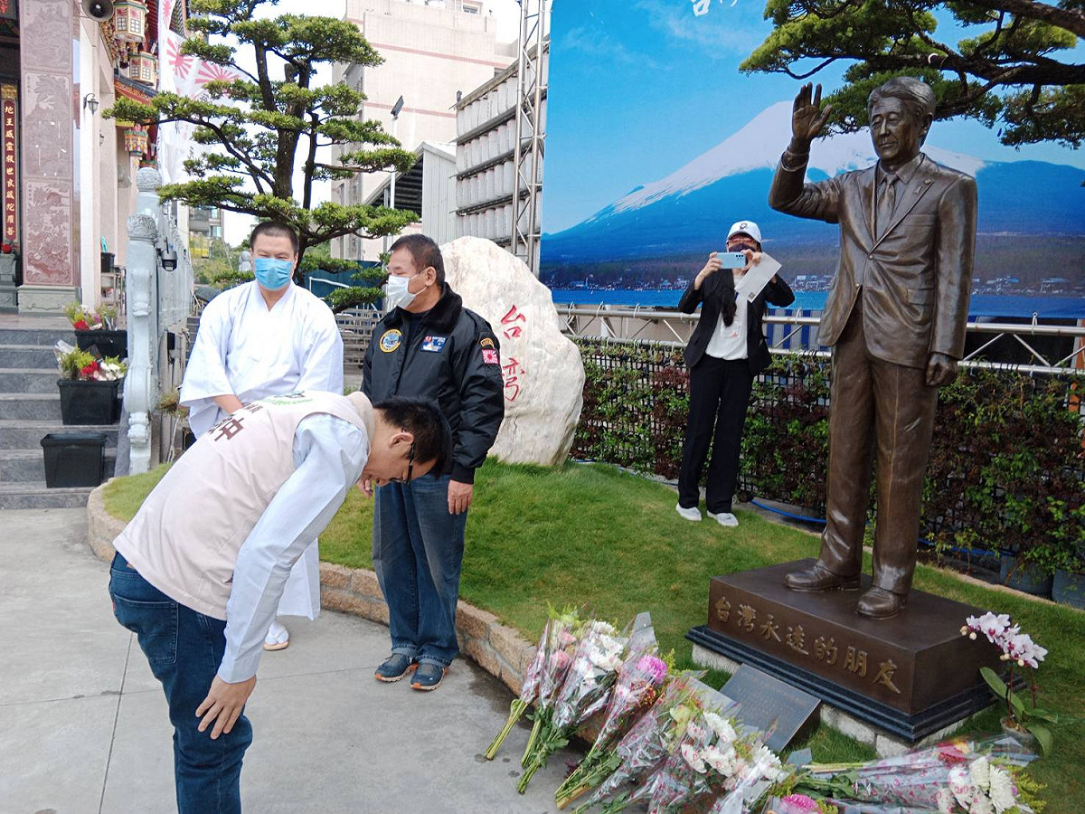 陳致中(左)向安倍晉三銅像行鞠躬禮。 圖：孫家銘攝
