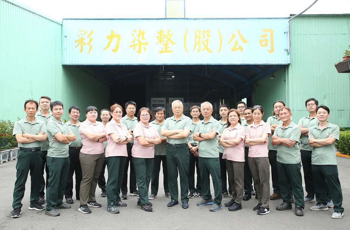 彩力染整公司董事長蘇慶福（前排圖中）說：「我經營的不是家族企業，而是企業家族。」 圖：醒吾科大提供