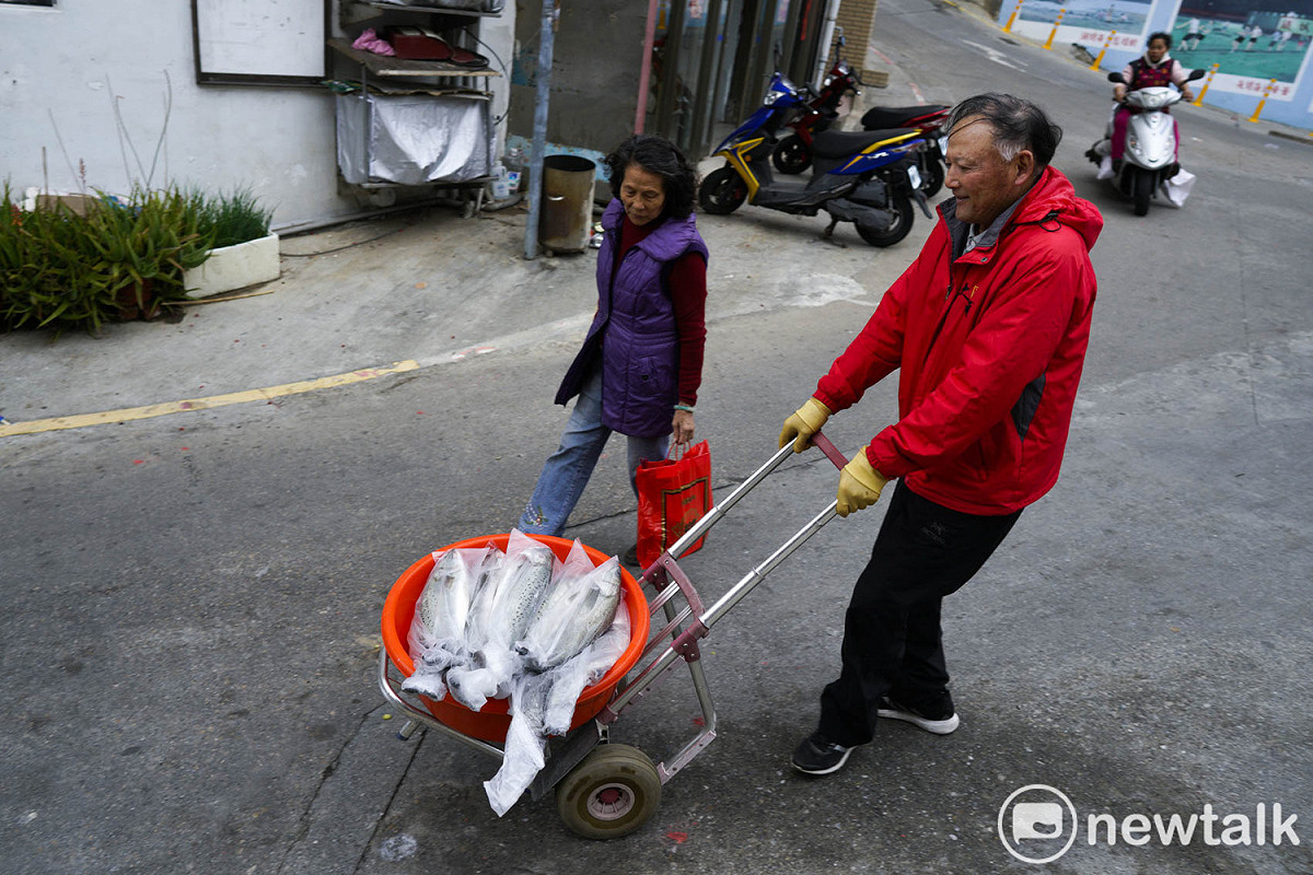 冬季是鱸魚大出的季節，曹天金伯伯忙著將剛剛釣到的鱸魚放冷凍庫，這些鱸魚冷凍後將裝箱賣到台灣。 圖：張良一/攝