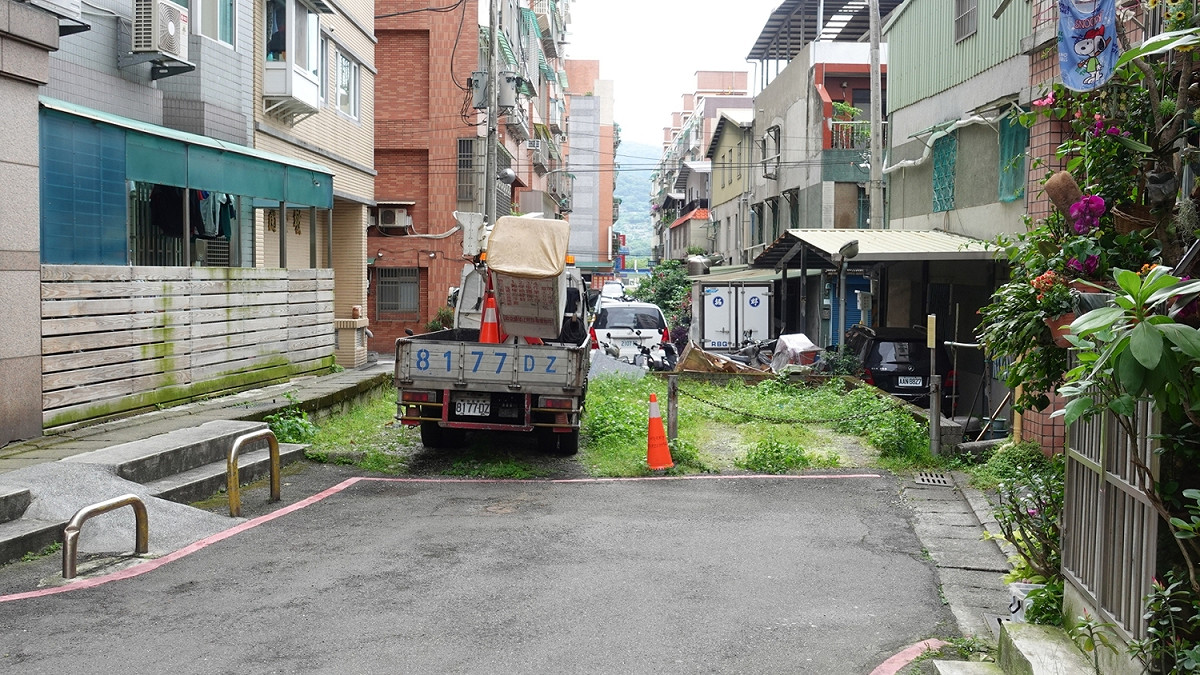 淡水民權路187巷66弄口國有地，曾被民眾用花圃及矮牆阻隔停車，無法通行。 圖：新北市工務局/提供