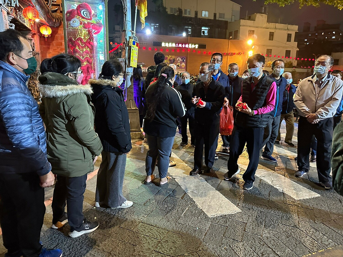 除夕夜，萬和宮董事長蕭清杰，贈送守候廟前的信眾錢母。 萬和宮/提供